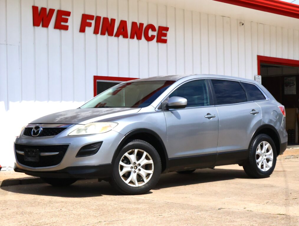 Silver SUV parked in front of a white building with a bold red 'WE FINANCE' sign