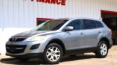 Silver SUV parked in front of a white building with a bold red 'WE FINANCE' sign