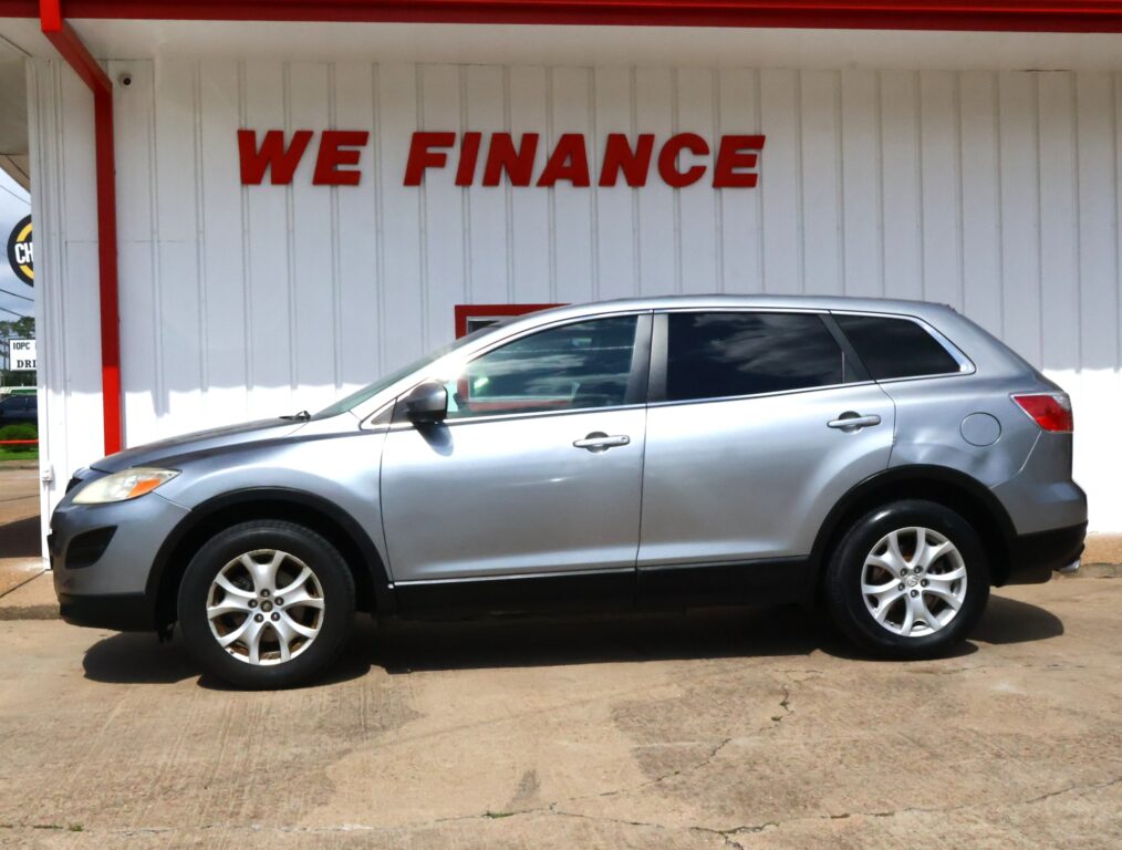 Silver SUV parked in front of a white wall with large red 'WE FINANCE' sign above.