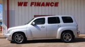Silver SUV parked in front of a white building with bold red 'WE FINANCE' sign above.