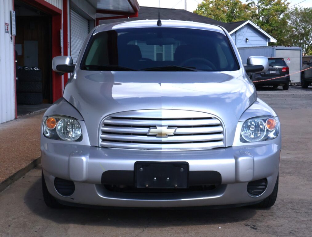 Front view of a silver Chevrolet SUV parked outdoors, showing the grille with the gold Chevrolet bowtie emblem and headlights.