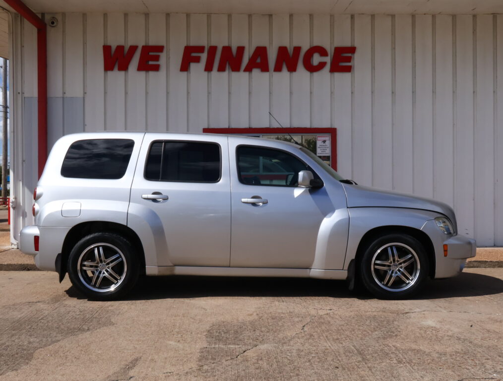 Silver SUV parked in front of a white wall with a red 'WE FINANCE' sign.