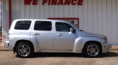 Silver SUV parked in front of a white wall with a red 'WE FINANCE' sign.