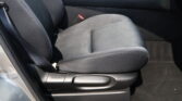 Car interior showing a front passenger seat with a visible red seat-belt buckle and center console area nearby.