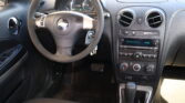 Front interior of a car showing the steering wheel, instrument cluster, and center console with radio and climate controls.