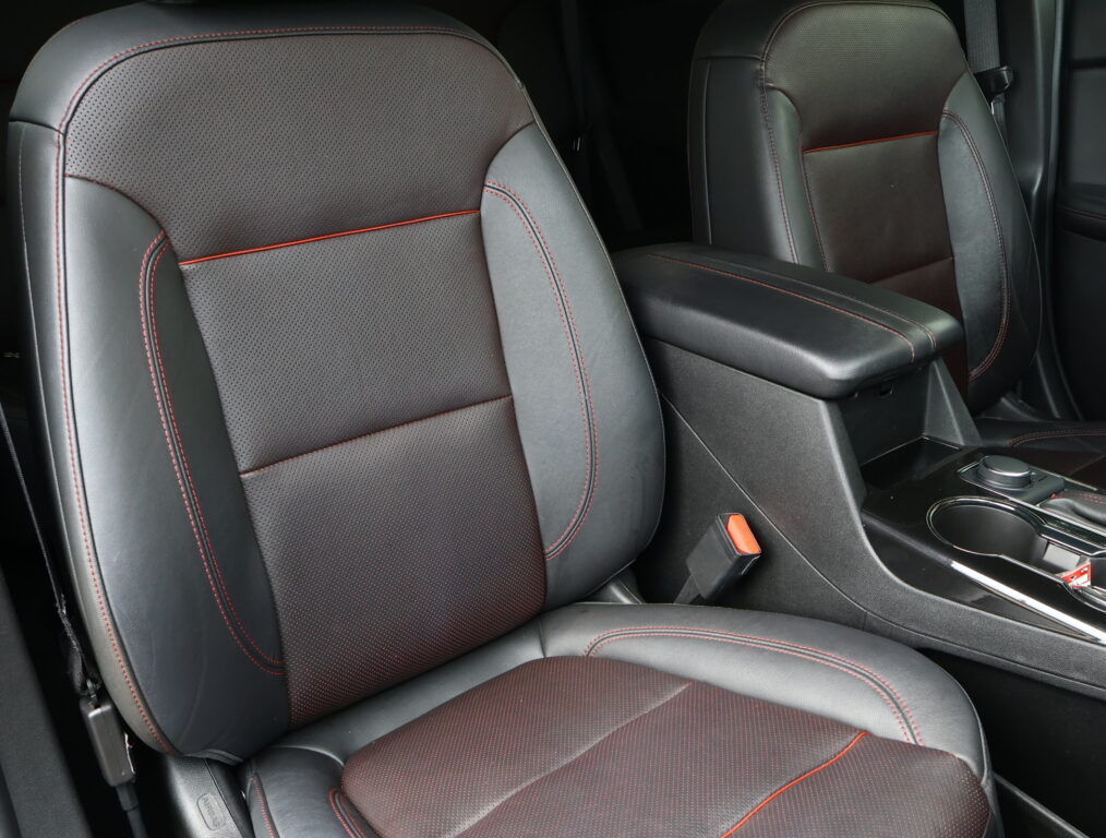 Front car seats upholstered in black leather with red contrast stitching and perforated centers they show a premium interior look.
