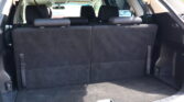 Rear cargo area of an SUV with back seats upright and black upholstery visible