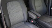 Interior of a car showing two front seats with gray patterned upholstery and visible seat belts.