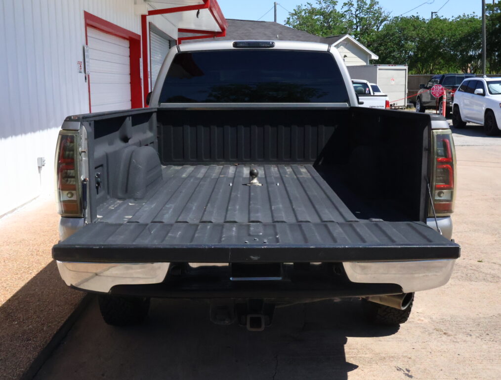 Rear view of a pickup truck with the tailgate down and empty bed in a parking lot