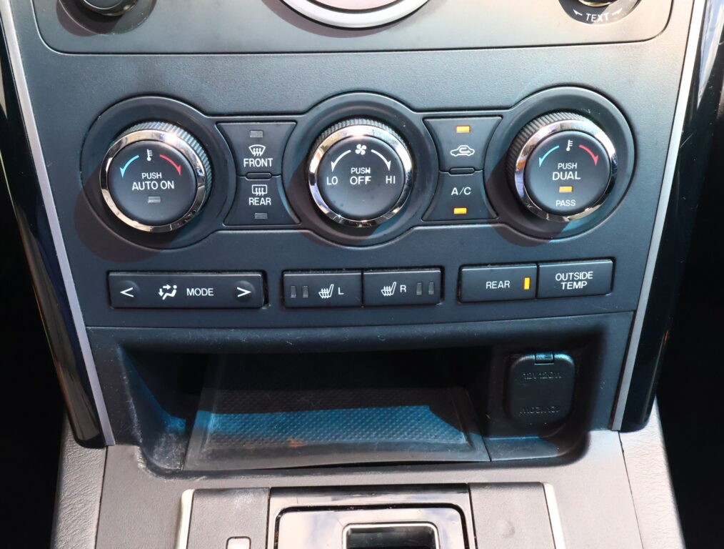 Car climate control panel with three knobs: left “Push Auto On,” center “Push Off/Lo–Hi,” right “Push Dual” for driver/passenger, plus A/C and defrost buttons above.