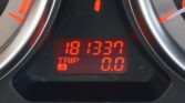 Close-up of a car dashboard digital display showing trip meters in red, with the numbers partially visible (0.00) and surrounding red indicators.