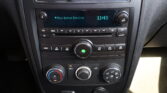 Car stereo display showing 'Aux Input Device' and the time 11:43, with knobs on both sides of the unit and climate controls below