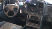 Interior of a pickup truck cabin with a steering wheel, gauge cluster, and a large center touchscreen display atop the dash.