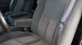 Gray fabric car interior showing rear seats with seat belts and a center console/cup holder area nearby