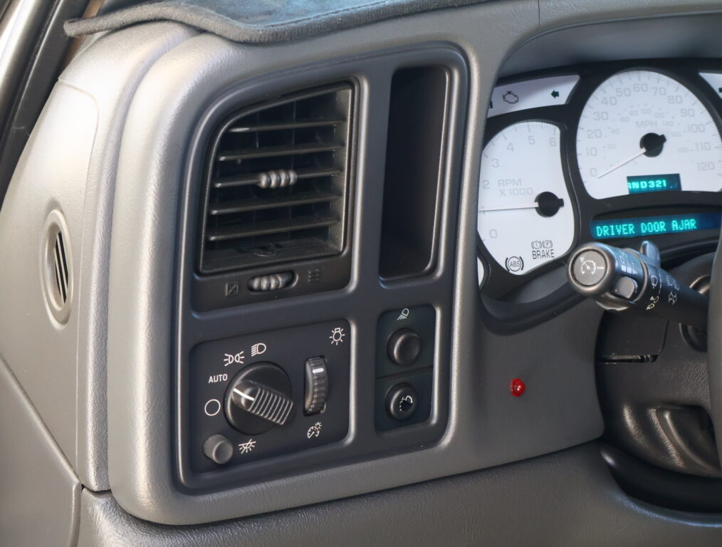 Close-up of the car dashboard on the driver’s side showing a rectangular air vent and climate control knobs nearby? careful: keep straightforward: Close-up of the driver’s side dashboard with a rectangular air vent and control knobs nearby.