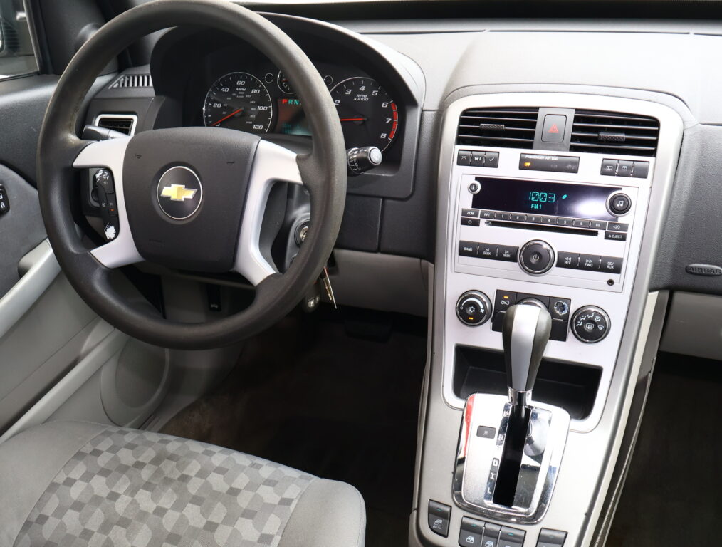 Interior of a car dashboard seen from the driver's seat, including steering wheel, instrument cluster, and center console with radio and climate controls