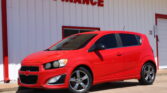 Red SUV parked in front of a white building with red trim and the words WE FINANCE on the wall beside it.