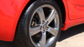Close-up of a red car wheel with a silver alloy rim and visible Chevrolet emblem at the center.