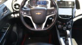 Dashboard view of a Chevrolet car interior with steering wheel, digital gauge cluster, and touchscreen infotainment center