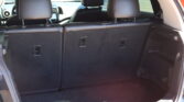 Interior view of the car's trunk with the rear seats upright and black upholstery visible