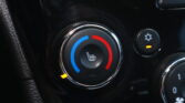 Close-up of a car climate control dial with blue and red temperature segments and the heated-seat icon in the center.