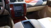 Beige car interior showing wood-grain dashboard trim, center console with navigation screen and climate controls.