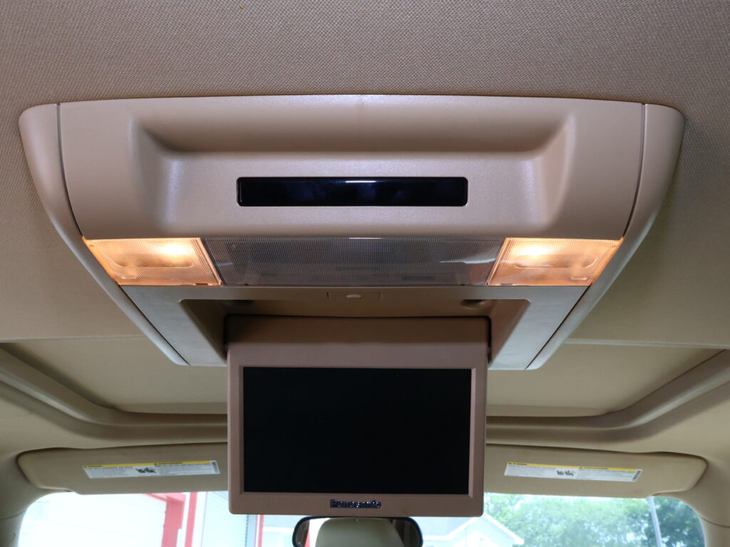 Overhead in-flight entertainment monitor mounted in the ceiling with two illuminated cabin lights on either side