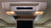 Overhead in-flight entertainment monitor mounted in the ceiling with two illuminated cabin lights on either side