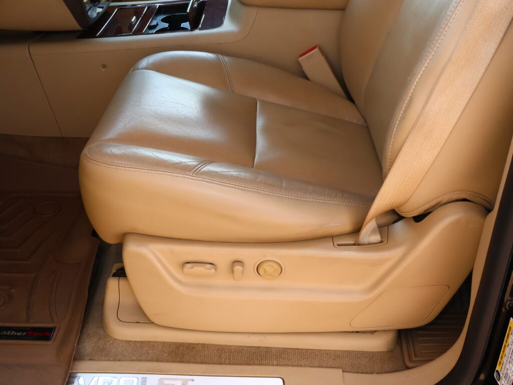 Beige leather car seat with center console and visible seat belt buckle