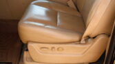 Beige leather car seat with center console and visible seat belt buckle