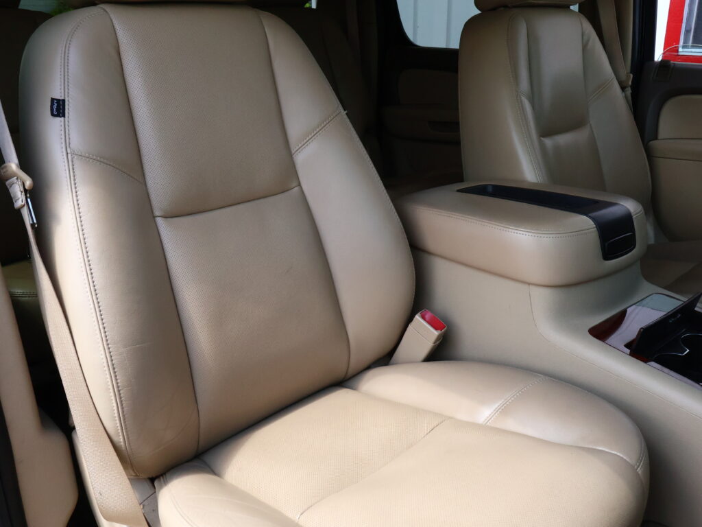 Beige perforated leather car seats with a beige center console in a vehicle, interior view. (informative)