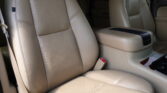 Beige perforated leather car seats with a beige center console in a vehicle, interior view. (informative)