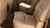Beige leather car interior with a captain's chair in the middle row and a rear door panel visible.