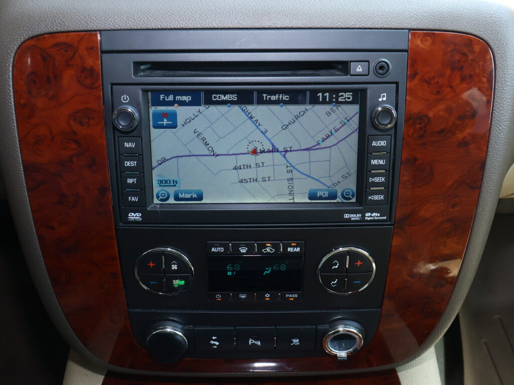 Car infotainment screen showing a GPS map with street names, surrounded by wood trim panels and climate controls below