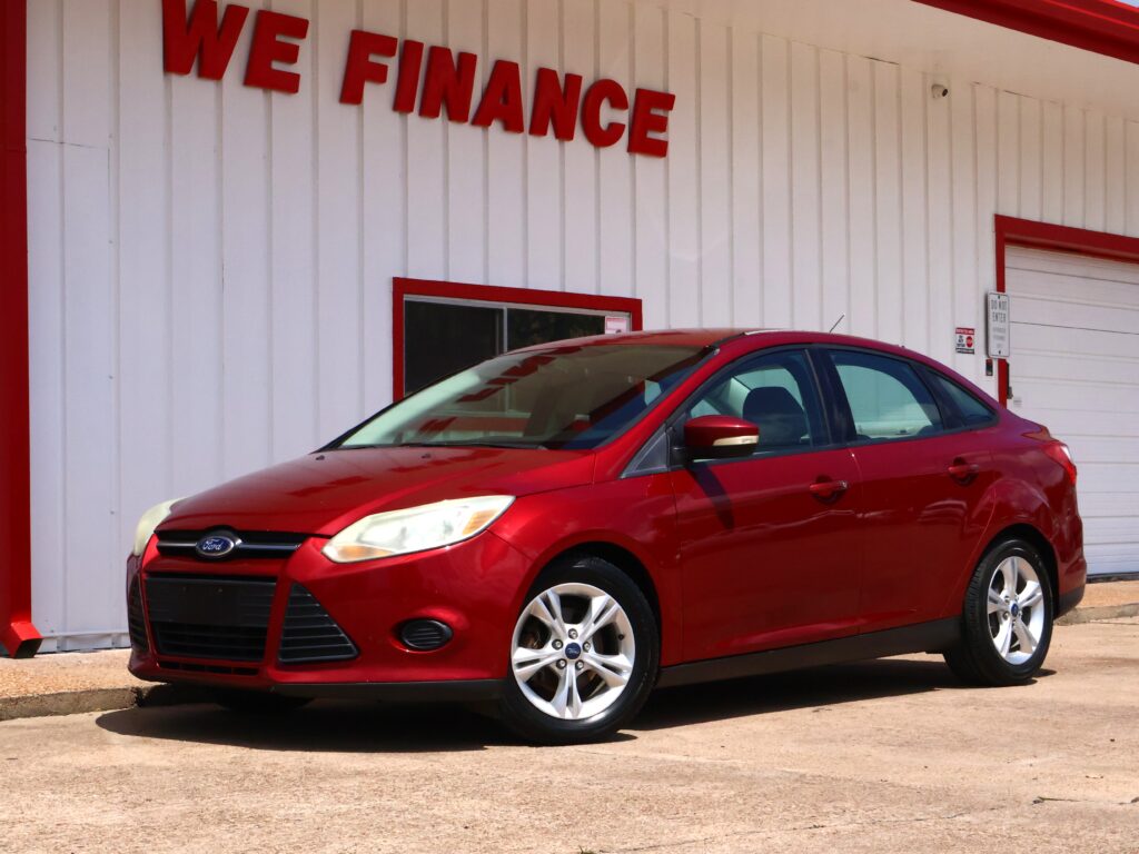 Red Ford SUV parked in front of a white building with red trim; the sign above reads 'WE FINANCE'.