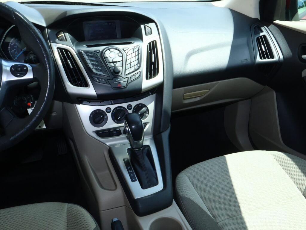 Interior of a car cabin focusing on center console, gear shifter, and passenger seat area.