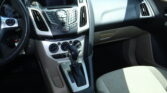 Interior of a car cabin focusing on center console, gear shifter, and passenger seat area.