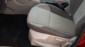 Front passenger seat and center console in a beige car interior, with the seat belt buckle visible near the seat edge