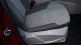 Front passenger seat in light gray fabric with center console and cup holder visible, car door frame at left.