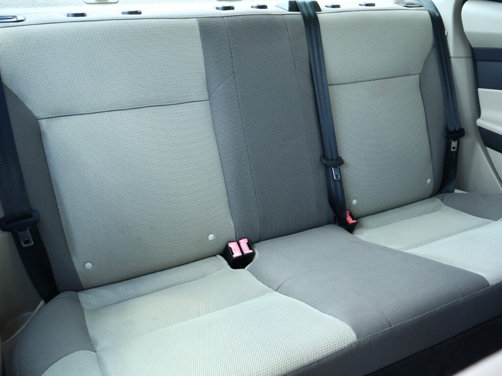 Rear car seat with three-point seat belts and gray upholstery