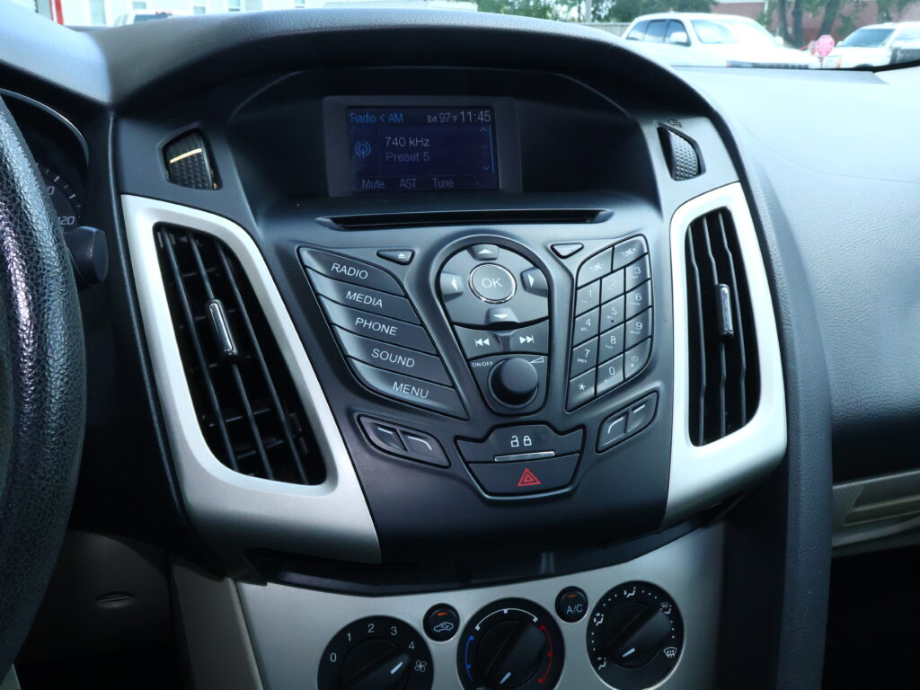 Close-up of a car's center dashboard showing the radio display and surrounding control buttons.