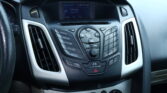 Close-up of a car's center dashboard showing the radio display and surrounding control buttons.