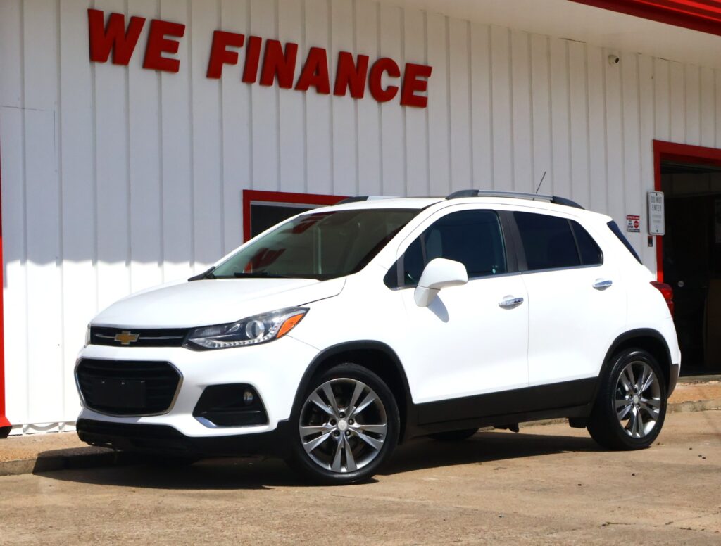 White Chevrolet SUV parked outside a white building with red trim and a bold 'We Finance' sign above.