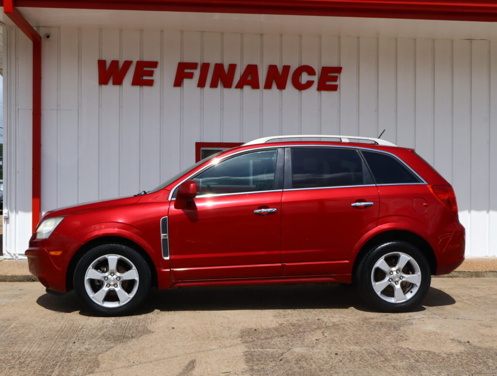 Red SUV parked in front of a white building with a bold red 'WE FINANCE' sign above the car.