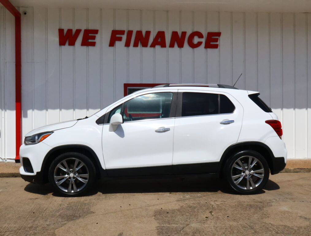 White SUV parked in front of a light wall with a red 'WE FINANCE' sign above it