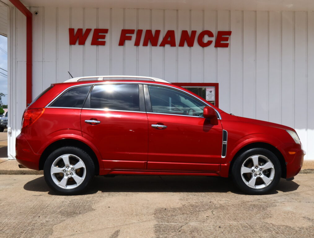 Red SUV parked in front of a white building with a bold 'WE FINANCE' sign above it, indicating a financing dealership.