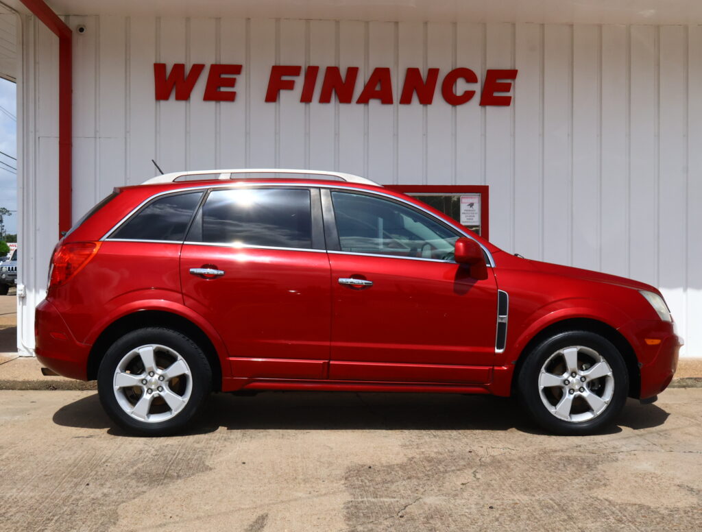 Red SUV parked in front of a white building with a bold 'WE FINANCE' sign above it, indicating a financing dealership.