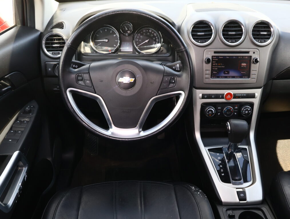 Interior view of a car dashboard featuring a round steering wheel with Chevrolet logo, instrument cluster, and center console with a touchscreen display and climate controls.