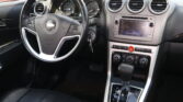 Dashboard interior: steering wheel in foreground, instrument cluster behind, and central touchscreen display with round air vents nearby