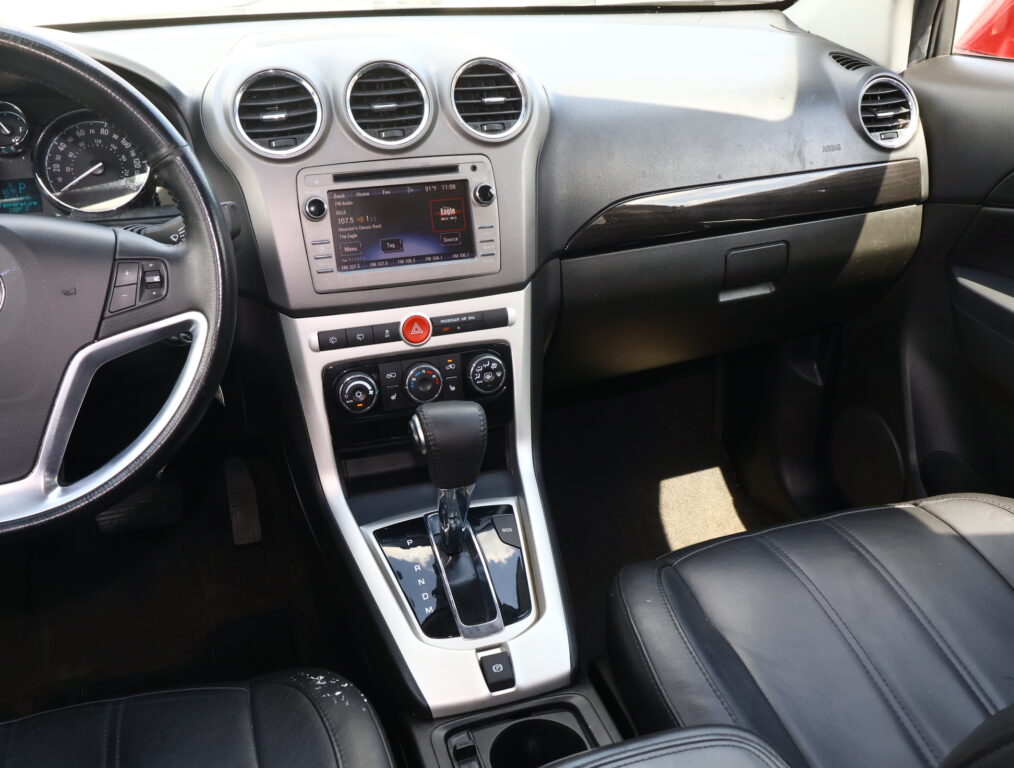 Interior view of a car dashboard showing a center touchscreen, three circular air vents, and the gear shifter surrounded by glossy trim.